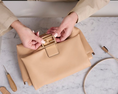 A FENDI artisan finishing a Mamma Baguette by hand