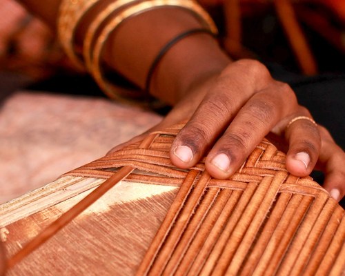 An artisan weaving leather by hand