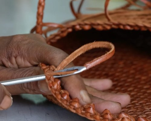 An artisan finishing a handle at the workshop in India
